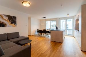 a living room with a couch and a kitchen and a table at CasaVia BB01 mit Parkplatz bis zu 7 Personen, zentral in Böblingen