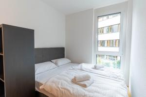 a white bedroom with a bed with towels on it at CasaVia BB01 mit Parkplatz bis zu 7 Personen, zentral in Böblingen +9 photos