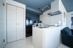 a white kitchen with a sink and a refrigerator at Hills Garden 405 in Sapporo
