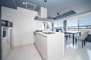a white kitchen with a table and a dining room at Hills Garden 405 in Sapporo +115 photos