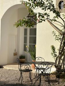 a table and two chairs in front of a building at Les Chambres du 11 - Chambres et Table d'hôtes in Chevigny