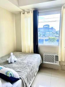 een kleine slaapkamer met een bed en een raam bij Dvine Era Staycation in Manilla