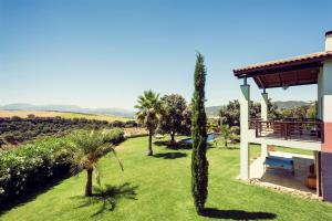 uitzicht op de tuin van een huis met palmbomen bij The Lodge Ronda in Ronda