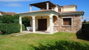 a small house with a table in the yard at Case Vacanza Fenicotteri in San Teodoro