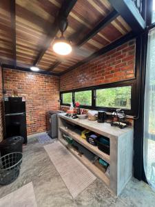 a kitchen with a brick wall and a counter at Royal Brick Cottage, Jelebu in Kuala Kelawang