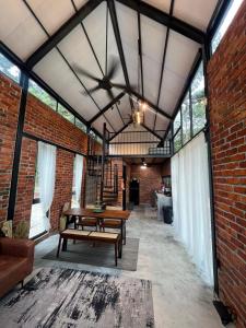 a large room with a table and a brick wall at Royal Brick Cottage, Jelebu in Kuala Kelawang