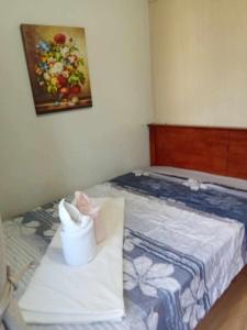 een kleine slaapkamer met een bed met een schilderij aan de muur bij Dvine Era Staycation in Manilla