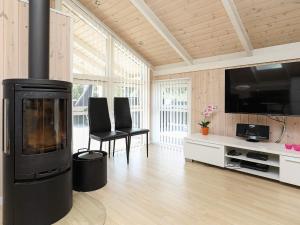 a living room with a fireplace and a flat screen tv at 9 person holiday home in Jerup in Jerup