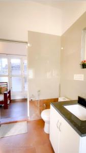 um banheiro branco com um vaso sanitário e uma pia em Arabica Homestay em Somvārpet mais 66 fotografias