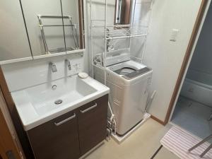 筑西市にあるOtsu Guest houseの洗面台と鏡のある小さなバスルーム
