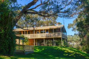 a large house on a hill with green grass at Iluka Retreat Glamping Village & Group Lodge Accommodation in Red Hill South
