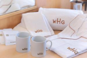 two white mugs sitting on a table with white towels at Urawa Washington Hotel in Saitama