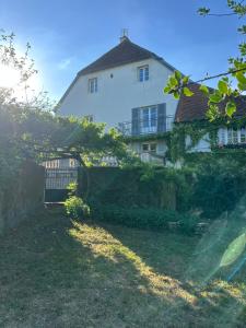 a large white building in front of a yard at Les Chambres du 11 - Chambres et Table d'hôtes in Chevigny