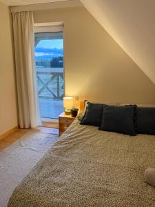 a bedroom with a bed and a large window at Dom na Kaszubach, Żuromino 2 0 in Żuromino
