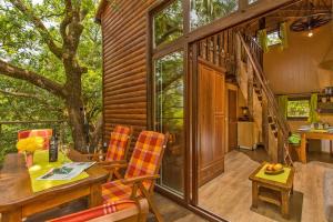 ein Wohnzimmer mit einem Tisch und Stühlen auf einem Haus in der Unterkunft Treehouse Dubrovnik in Čilipi