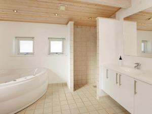 ein weißes Badezimmer mit Badewanne und Waschbecken in der Unterkunft 6 person holiday home in Hirtshals-By Traum in Hirtshals + 19 Fotos