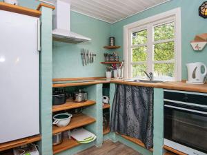 a kitchen with a counter with a sink and a window at 5 person holiday home in Ans By in Roe