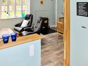 a living room with black leather chairs and a table at 5 person holiday home in Ans By in Roe