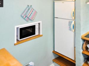 a microwave on a wall next to a refrigerator at 5 person holiday home in Ans By in Roe