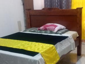 a bed with colorful sheets and a pillow on it at Royalcarevillas in Thika