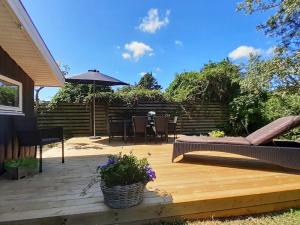 a wooden deck with a table and an umbrella at 5 person holiday home in Sæby-By Traum in Sæby
