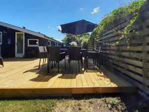 a wooden deck with chairs and an umbrella at 5 person holiday home in Sæby-By Traum in Sæby