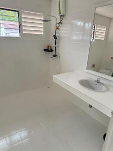 a white bathroom with a sink and a mirror at 御澜东方 in Jomtien Beach +14 photos