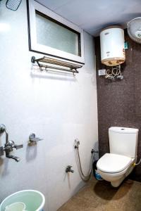 a bathroom with a toilet and a window and a sink at Sher E Punjab Home Stay in Agra