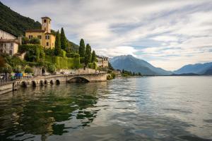 a view of a river with buildings and a bridge at Al Laghée - New 2 Bedroom Apartment in Gravedona Center in Gravedona