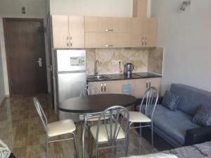uma cozinha com uma mesa e cadeiras e um sofá em Studio Apartment On Khimshiashvili 15 em Batumi