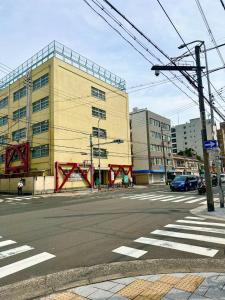 an intersection of an empty street with a building at Queen's Park 空港直通 新今宮駅 通天閣 新世界 in Osaka