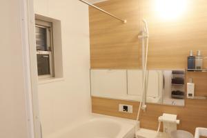 a bathroom with a tub and a sink and a mirror at Dori Dori House Shinjuku1 in Tokyo +38 photos