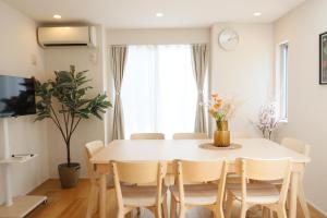 a dining room with a white table and chairs at Dori Dori House Shinjuku1 in Tokyo