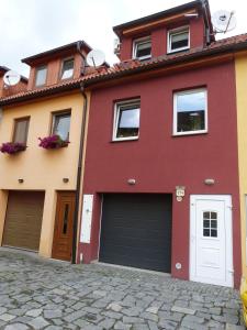 a red house with two garage doors on a street at Apartmán Susice in Sušice