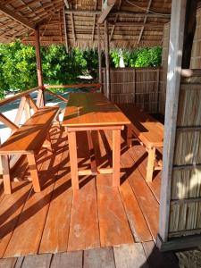 a wooden picnic table and benches on a deck at Merpati homestay in Merpati