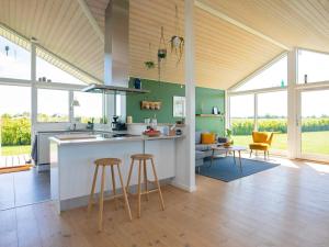 オテルプにある9 person holiday home in Otterup-By Traumのオープンキッチン(カウンター、スツール付)