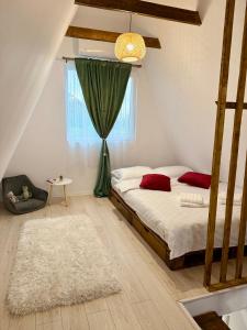 a bedroom with a bed with red pillows and a window at Serra Luna Sibiel in Sălişte