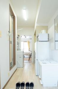 a room with a white refrigerator and a hallway at UPHouse 2C Gotokuji in Tokyo