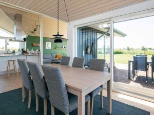 オテルプにある9 person holiday home in Otterup-By Traumの木製のテーブルと椅子のあるキッチンとダイニングルーム +16枚の写真