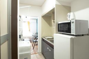 a kitchen with a microwave on top of a refrigerator at UPHouse 2C Gotokuji in Tokyo