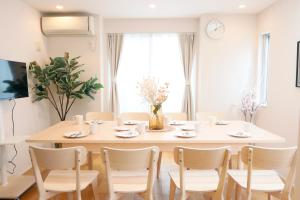 a white dining room with a table and chairs at Dori Dori House Shinjuku1 in Tokyo