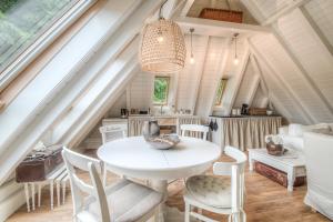 a dining room with a white table and chairs at Appartement De Koesfabriek centrum Dokkum in Dokkum