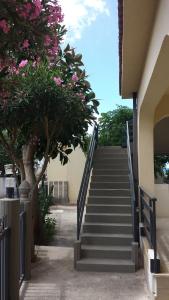 una escalera que conduce a un edificio con flores rosas en Oasi Marina, en Alcamo Marina