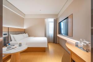 a hotel room with a bed and a table at JI Hotel Beijing West Railway Station in Beijing