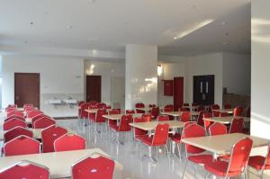 une chambre avec des tables, des chaises et des chaises rouges dans l'établissement I&M Hotel Billiard, à Surabaya