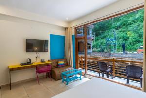 a room with a bed and a desk and a window at goSTOPS Kasol PLUS, Manikaran Road - Private Rooms & Dorms in Kasol