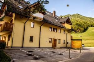 克拉尼斯卡戈拉Apartment Katarina Kranjska Gora的停车场内有大门的大型黄色建筑 更多18张照片