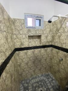 a bathroom with a shower with a window at Residencial Costa Mar in Puerto Cortes