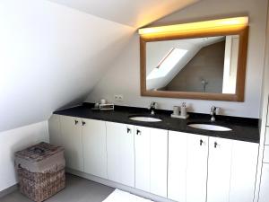 a bathroom with two sinks and a mirror at ZEEZANDPAREL Westende-Bad Gezellig 3-slaapkamer appartement in Westende-Bad