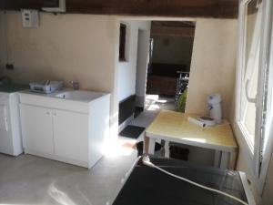 eine Küche mit Spüle und Tisch in einem Zimmer in der Unterkunft Le Cottage " Village de La Ruée " Location de vacances in Plurien + 18 Fotos